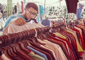 A man looking at a t-shirt in a clothing store
