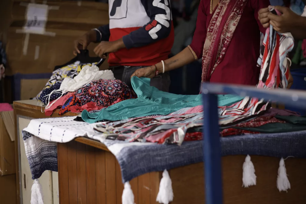 People folding various graded goods in a warehouse.