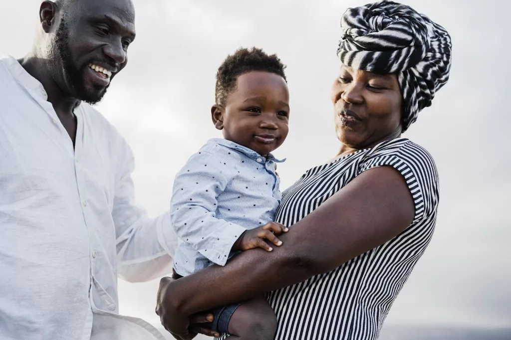 An African boy held by his parents